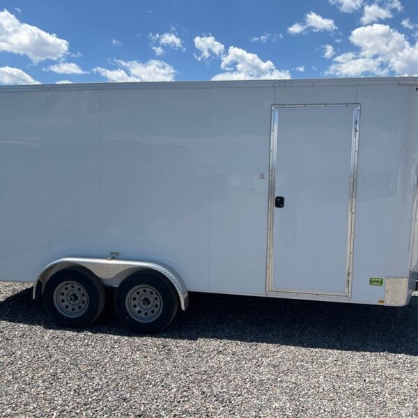 White Xpress enclosed cargo trailer with dual axles, side door, and diamond plate fenders, parked on gravel
